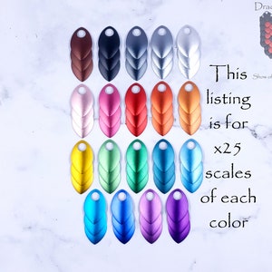 May include: Twenty-five dragon scales in ten different colors. The scales are made of metal and have a shiny finish. The colors are brown, black, gray, silver, pink, red, orange, gold, green, blue, and purple.