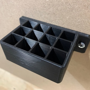 May include: Black plastic wall-mounted organizer with 16 compartments.