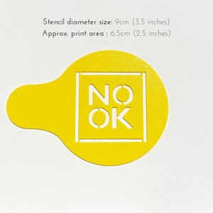 May include: Yellow plastic stencil with a 3.5 inch diameter. The stencil is shaped like a circle with a small handle on the side. The stencil has the words "NO OK" cut out in a white square.