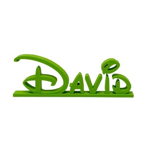 May include: A vibrant green decorative sign spelling out "David" in a distinctive font. The design includes a recognizable logo element, with the name sitting on a flat base. The sign is made of a solid material.