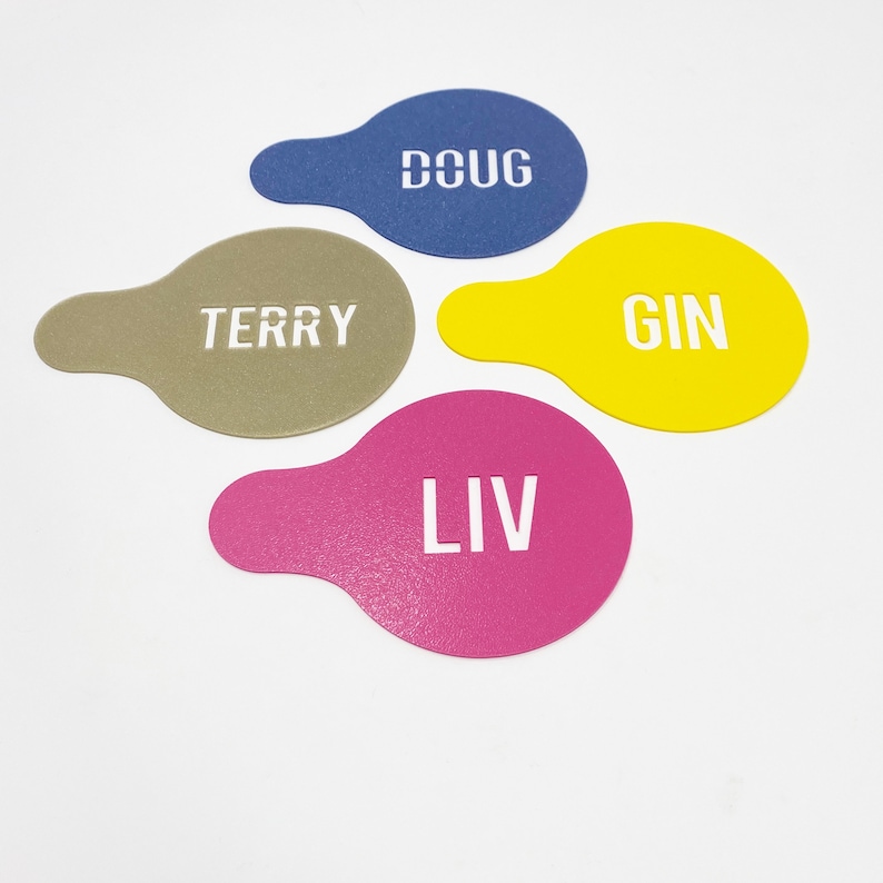 May include: Four colorful stencils with the names "Doug", "Terry", "Gin", and "Liv" written in white.