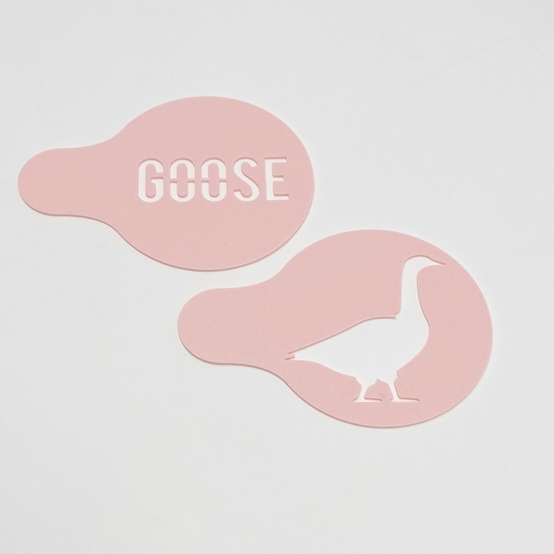 May include: Two pink plastic stencils, one with the word "GOOSE" cut out and the other with a goose silhouette cut out.