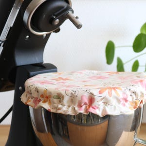 Könnte beinhalten: Eine Edelstahl-Schüssel mit einem floralen Stoffbezug. Die Schüssel steht auf einem Standmixer.