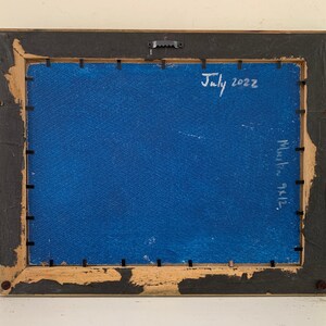 K&ouml;nnte beinhalten: Die R&uuml;ckseite eines gerahmten Gem&auml;ldes mit blauem Hintergrund. Der Rahmen ist aus Holz und hat eine schwarze Oberfl&auml;che. Das Gem&auml;lde ist mit "Juli 2022" und "9x12" in wei&szlig;er Farbe signiert.