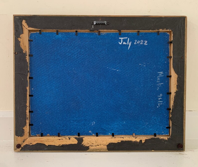K&ouml;nnte beinhalten: Die R&uuml;ckseite eines gerahmten Gem&auml;ldes mit blauem Hintergrund. Der Rahmen ist aus Holz und hat eine schwarze Oberfl&auml;che. Das Gem&auml;lde ist mit "Juli 2022" und "9x12" in wei&szlig;er Farbe signiert.