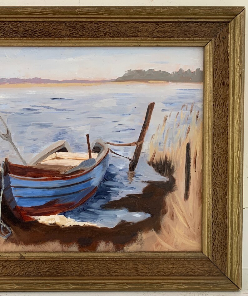 K&ouml;nnte beinhalten: Ein Gem&auml;lde, das ein blaues und rotes Holzboot zeigt, das an einem Holzpfosten am Ufer eines Sees festgemacht ist. Das Wasser ist hellblau und der Himmel ist hellgrau. Im Hintergrund sind B&auml;ume zu sehen.