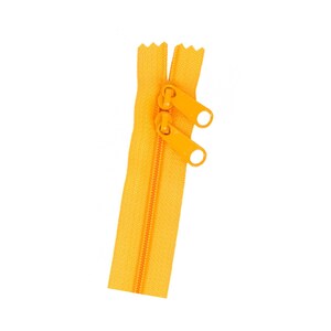 May include: A yellow zipper with a metal slider and pull tab.