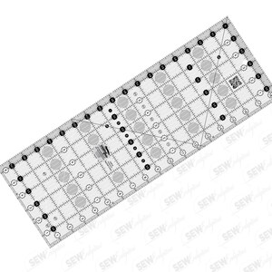 May include: A clear, rectangular quilting ruler with black and gray markings. The ruler features a grid pattern, circles, and angled lines for precise cutting. The ruler is designed for sewing and quilting projects.