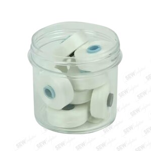 May include: A clear plastic jar filled with several white thread spools. Each spool has a blue center. The jar is sitting on a white background. The image has the watermark "SEW" repeated across the image.