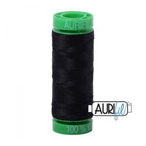 May include: A spool of black thread with green plastic ends. The spool is labeled "Aurifil" and "100% Cotton".