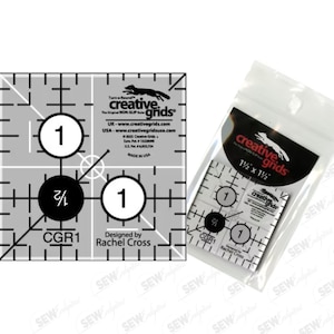 May include: A Creative Grids quilting ruler, 1.5 x 1.5 inches, with black and white markings and the text "CGR1". The ruler is packaged in a clear plastic bag. The design includes circles with numbers and fractions.