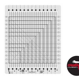 May include: A white plastic quilting ruler with black lines and numbers. The ruler has a grid pattern with squares and triangles. The ruler is labeled "Creative Grids" and "Non-Slip".