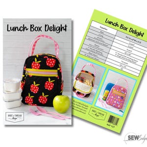 May include: A sewing pattern titled Lunch Box Delight featuring a quilted black lunch bag with a red apple print, pink gingham handles, and a yellow zipper. The pattern includes a supply list, finished dimensions of 9.5 inches H x 8 inches W x 6 inches D, and photos of the bag.