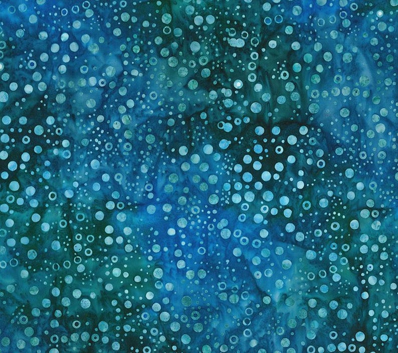 May include: A fabric with a mottled pattern in shades of blue and teal. The design features a scattering of white and light blue circles of varying sizes, creating a textured, aquatic appearance. The fabric has a batik-like quality.