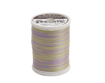 May include: A spool of Sulky 100% Cotton/Cotton Mercerized thread in a green, purple, and yellow color combination. The spool is labeled "Sulky 100% Cotton/Cotton Mercerized Use #80/100 Top Stitch Needles 733 4024".