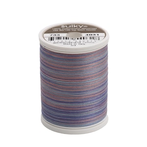 May include: A spool of Sulky 100% cotton mercerized thread in a multi-colored pattern of blue, pink, and white. The spool is labeled with the number 733 and 4031. The text "Sulky" is printed on the spool. The text "100% Cotton Mercerized" is printed on the spool. The text "Use 90/100 Top Stitch Needle" is printed on the spool. The text "Made in Italy" is printed on the spool.
