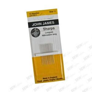 May include: A package of John James Sharps sewing needles, size 11, with 12 needles. The packaging is yellow and white, with the brand name and product details printed in black. The text "Made in England" is also visible.