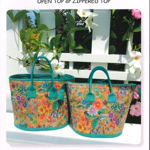 May include: Two cork tote bags with floral patterns. The bags have teal handles and trim. The larger bag is 11.25 inches wide, 9 inches deep, and 9.5 inches tall. The smaller bag is 9.5 inches wide, 7 inches deep, and 9.5 inches tall. The text on the image says "Aunties Two Patterns Cork Totes".