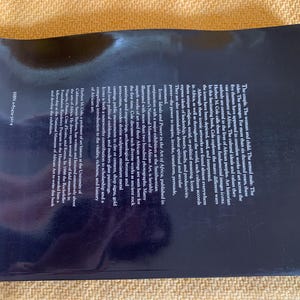 May include: A hardcover book titled "Icons: Ideals and Power in the Art of Africa." The book's cover is dark blue with text and a glossy finish. The book explores African art, featuring numerous photographs.