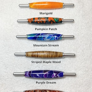 May include: Six different colored tools, each with a silver handle and a different colored handle. The tools are labeled "Marigold", "Pumpkin Patch", "Mountain Stream", "Striped Maple Wood", "Purple Dream", and "Copper Ore". All 2 in 1 tools are same size.