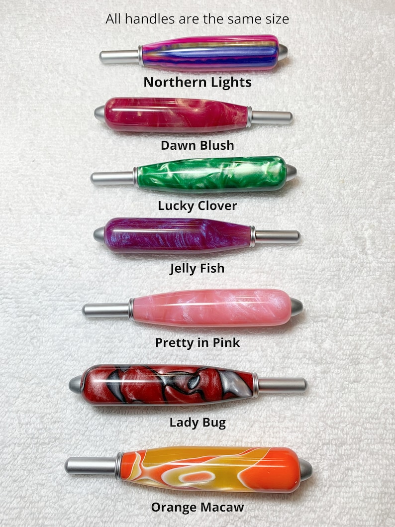 May include: Seven cylindrical handles with silver-toned metal ends, each featuring a unique marbled resin pattern. The text labels are Northern Lights, Dawn Blush, Lucky Clover, Jelly Fish, Pretty in Pink, Lady Bug, Orange Macaw, and All handles are the same size.
