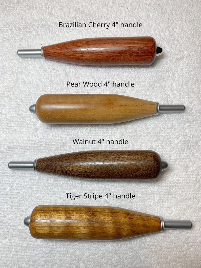 Może przedstawiać: Cztery r&oacute;żne drewniane uchwyty do narzędzi, każdy z końc&oacute;wką ze srebrnego metalu. Uchwyty są oznaczone jako "Brazilian Cherry 4" handle", "Pear Wood 4" handle", "Walnut 4" handle" i "Tiger Stripe 4" handle".