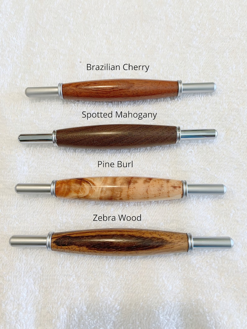 May include: Four wooden dowel rods with silver metal ends. The wood types are labeled: Brazilian Cherry, Spotted Mahogany, Pine Burl, and Zebra Wood.