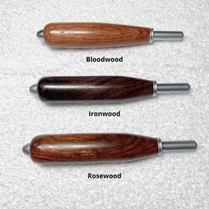May include: Three wooden handles with metallic tips, labeled Bloodwood, Ironwood, and Rosewood. Each handle features a smooth, cylindrical shape with a rounded end and a silver-toned ferrule. The text states: All handles are same size.