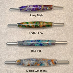 May include: Four different crochet hooks with colorful marbled handles. The handles are labeled "Starry Night", "Earth's Core", "Tidal Pool", and "Glacial Symphony". All 2 in 1 tools are the same size.