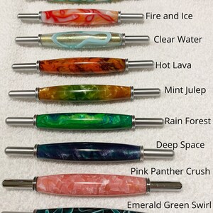 May include: Nine seam rippers with decorative resin handles in various colors and patterns, labeled Key Lime, Fire and Ice, Clear Water, Hot Lava, Mint Julep, Rain Forest, Deep Space, Pink Panther Crush, and Emerald Green Swirl. Text: All seam rippers are the same size.