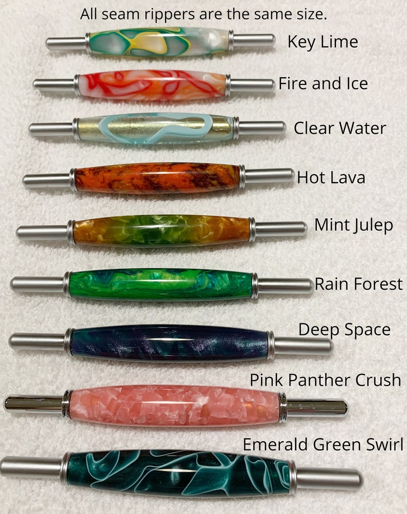 May include: Nine seam rippers with decorative resin handles in various colors and patterns, labeled Key Lime, Fire and Ice, Clear Water, Hot Lava, Mint Julep, Rain Forest, Deep Space, Pink Panther Crush, and Emerald Green Swirl. Text: All seam rippers are the same size.
