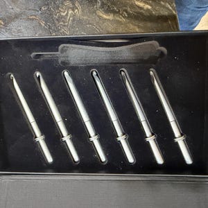Op de afbeelding: Een set van drie keramische mokken met een gespikkelde, matte afwerking. De mokken zijn in tinten cr&egrave;me, lichtgrijs en donkergrijs. Elke mok heeft een eenvoudig, minimalistisch ontwerp, perfect voor koffie of thee.