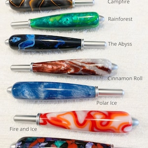 May include: Seven resin handles with silver-toned metal tips, each featuring unique color patterns labeled as Campfire, Rainforest, The Abyss, Cinnamon Roll, Polar Ice, Fire and Ice, and Stained Glass. Text states: All handles are the same size.