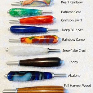 May include: Ten craft tool handles with silver metal tips, arranged vertically. Colors include Outa this Swirl, Pearl Rainbow, Bahama Seas, Crimson Swirl, Deep Blue Sea, Rainbow Camo, Snowflake Crush, Ebony, Abalone, and Fall Harvest Wood.