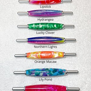 May include: Seven cylindrical handles with metallic ends, each featuring a unique acrylic pattern. The patterns are labeled as Lipstick, Hydrangea, Lucky Clover, Northern Lights, Orange Macaw, Lily Pond, and Pink Flamingo. Text states: All handle are the same size.