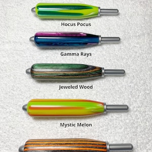 May include: Five cylindrical handles with metallic tips, labeled: Hocus Pocus (green/yellow), Gamma Rays (purple/blue), Jeweled Wood (green/brown), Mystic Melon (yellow/orange), and Halloween Woods (orange/black). Text states: All the handles are same size.