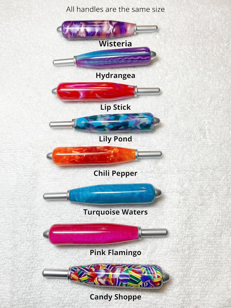 May include: Eight crochet hook handles with silver metal tips, arranged vertically. Colors include purple and white swirl, blue and purple, red and white, blue and purple mosaic, orange, turquoise, bright pink, and a multi-colored candy pattern.