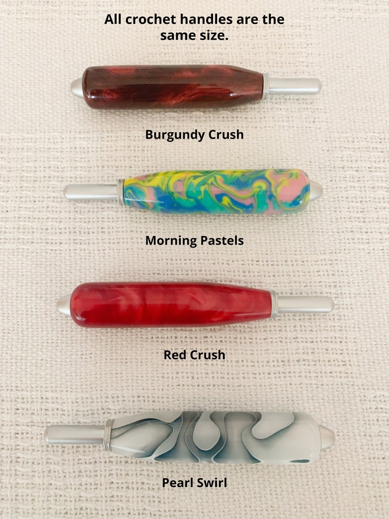 May include: Four crochet hooks with thick, polished handles in Burgundy Crush, Morning Pastels, Red Crush, and Pearl Swirl patterns. Each handle features a metallic silver tip and base. Text reads: All crochet handles are the same size.
