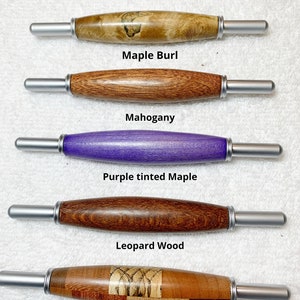 May include: Five different wooden pen handles with silver metal ends. The handles are made of maple burl, mahogany, purple tinted maple, leopard wood, and patchwork woods. All handles are the same size. "All handles are the same size" is written at the top of the image.