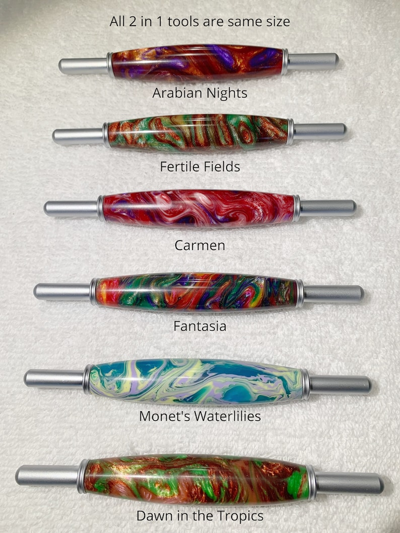 May include: Six different crochet hooks with colorful, marbled handles. The handles are labeled with names like "Arabian Nights", "Fertile Fields", "Carmen", "Fantasia", "Monet's Waterlilies", and "Dawn in the Tropics".