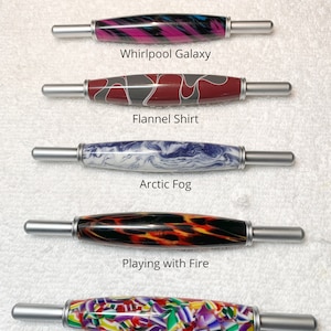 May include: Five 2-in-1 tools with silver metal ends and patterned acrylic barrels. The patterns are labeled Whirlpool Galaxy, Flannel Shirt, Arctic Fog, Playing with Fire, and Candy Shoppe. Text states: All 2 in 1 tools are same size.
