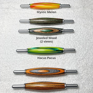 May include: Five different wooden tools with metal handles. The tools are all the same size and are arranged vertically. The tools are labeled with the names "Mystic Melon", "Jeweled Wood (2 views)", "Hocus Pocus", "Halloween Wood (2 views)".