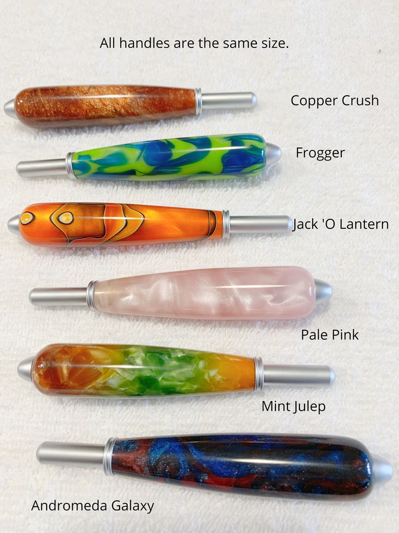 May include: Six cylindrical handles with silver-toned metal tips, labeled Copper Crush, Frogger, Jack 'O Lantern, Pale Pink, Mint Julep, and Andromeda Galaxy. The text states: All handles are the same size. Each handle features a unique resin pattern.