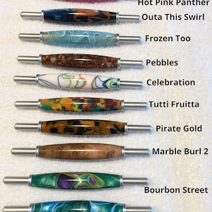 May include: Ten different colored and patterned crochet hooks with silver handles. The hooks are labeled with names such as "Hot Pink Panther", "Outa This Swirl", "Frozen Too", "Pebbles", "Celebration", "Tutti Fruitta", "Pirate Gold", "Marble Burl 2", "Bourbon Street", and "Ocean Currents".