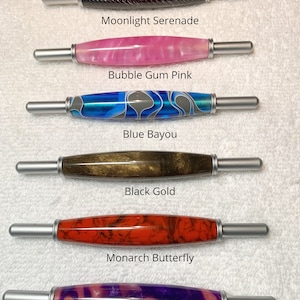 May include: Six 2-in-1 tools with silver metal ends and patterned barrels labeled Moonlight Serenade, Bubble Gum Pink, Blue Bayou, Black Gold, Monarch Butterfly, and Wisteria. The text states: All 2 in 1 tools are same size.