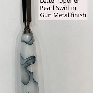 May include: A heavy duty letter opener with a metallic blade and a handle featuring a white and gray pearl swirl pattern. The text on the image reads: Heavy Duty Letter Opener Pearl Swirl in Gun Metal finish. The design includes a smooth, rounded handle.