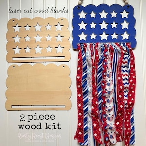 May include: A 2-piece wood kit with laser-cut wood blanks. One piece features star cutouts, and the other is a solid wood piece. A blue wooden sign with white star cutouts and red, white, and blue fabric streamers hangs from the top. The text "laser cut wood blanks" and "2 piece wood kit" are visible.