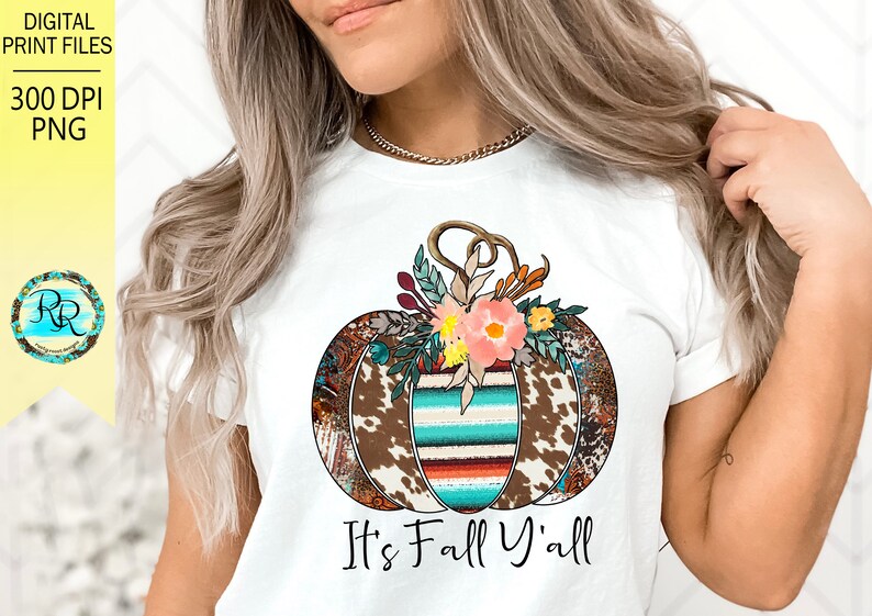 May include: White t-shirt with a brown, white, and turquoise pumpkin with floral accents. The text "It's Fall Y'all" is printed below the pumpkin.