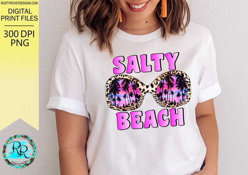 May include: White t-shirt with a pink graphic design that says "Salty Beach" with a pair of sunglasses with a leopard print frame and a palm tree design inside the lenses.