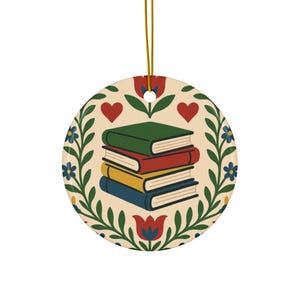 Peut inclure: Ornement rond en céramique avec une pile de livres verts, rouges, jaunes et bleus. L'ornement a un fond crème avec un motif floral et en forme de cœur. Une ficelle dorée est attachée pour l'accrocher.
